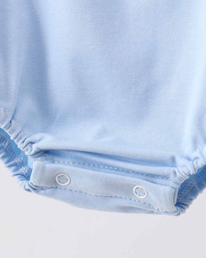 Close-up of a light blue baby romper with button details on a white background