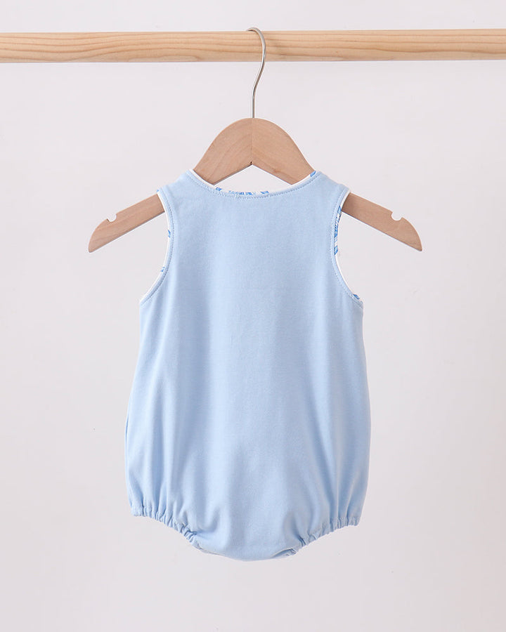 Light blue baby romper on a wooden hanger against a light background