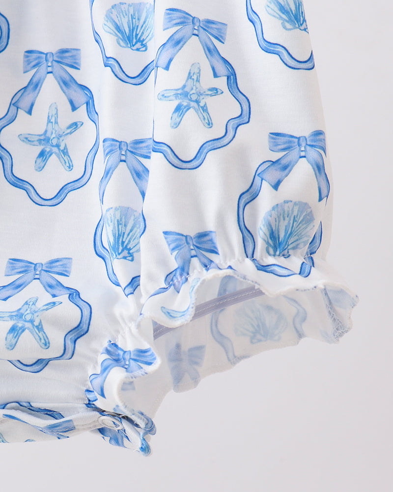 White fabric with blue starfish and shell pattern on a white background