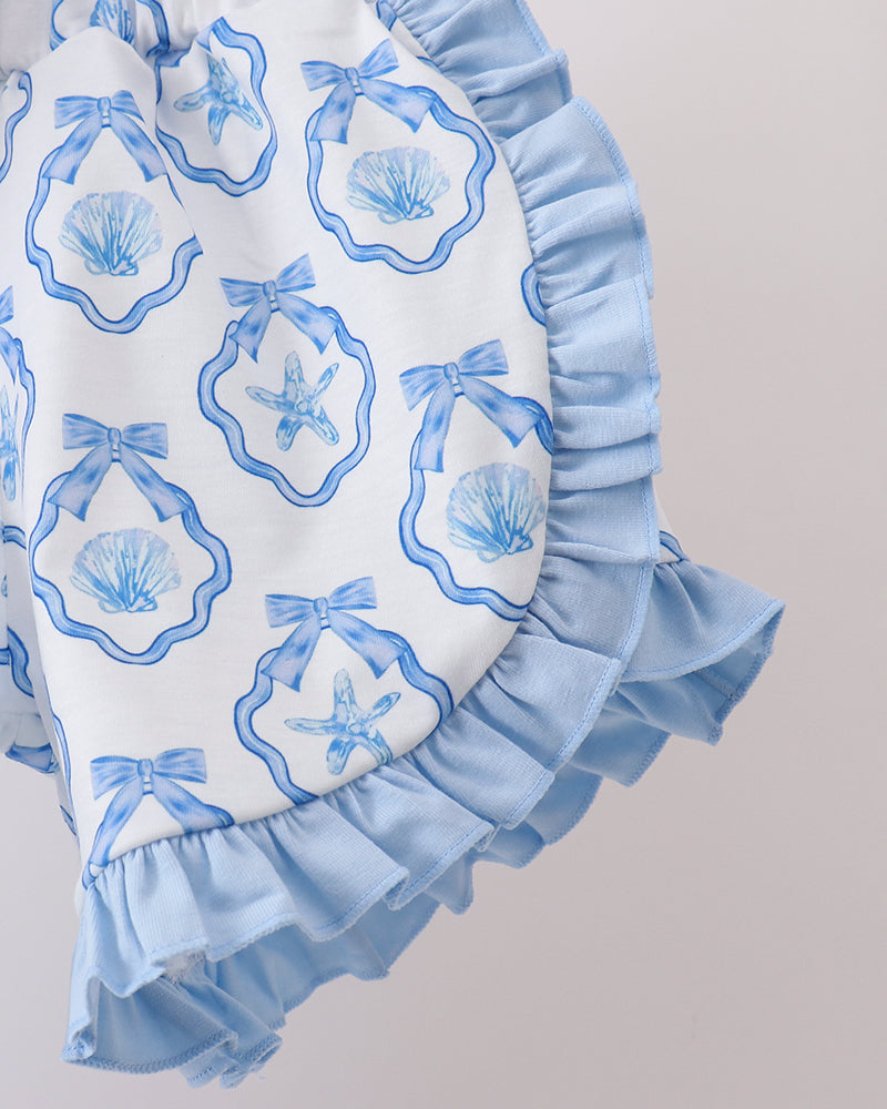 Shorts with blue ruffles and shell pattern on a plain background