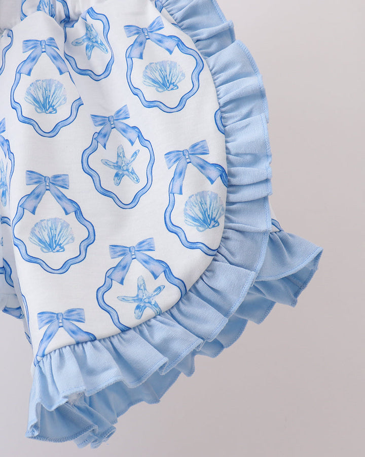 Shorts with blue ruffles and shell pattern on a plain background