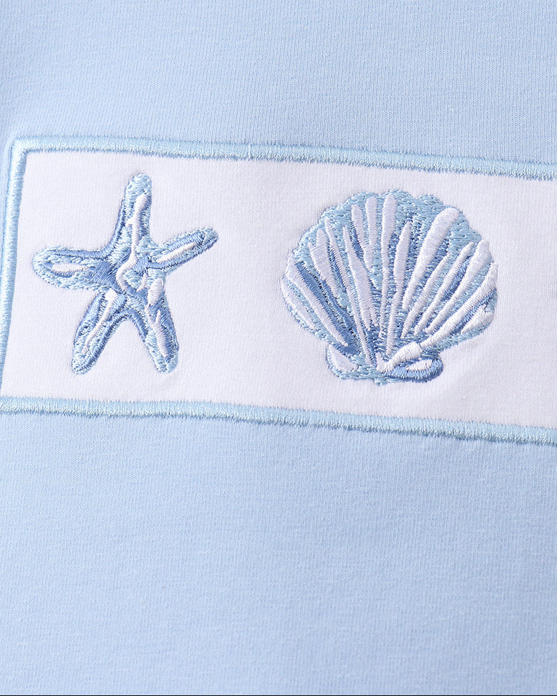 Light blue fabric with embroidered starfish and shell design
