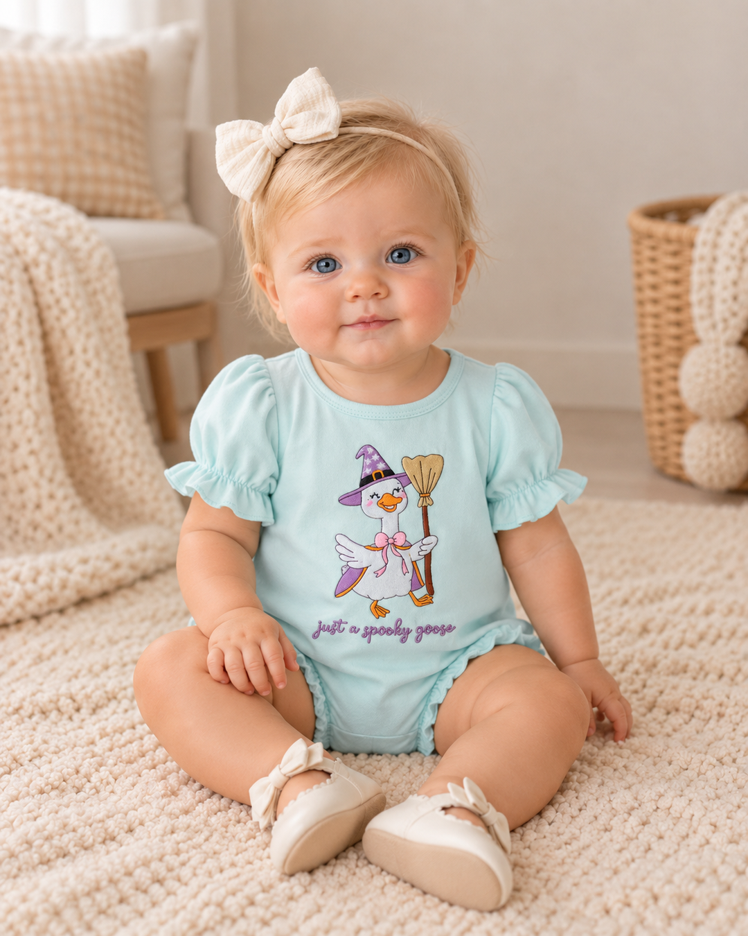 Baby girl is wearing a Blue Spooky Goose Embroidered Bubble