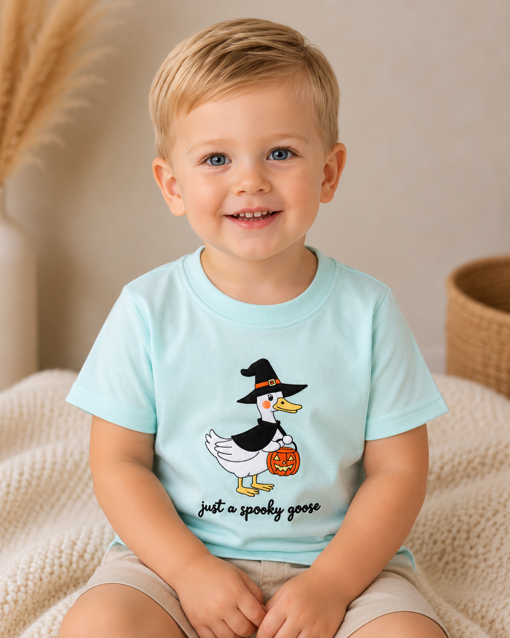 Toddler boy is wearing a Blue Spooky Goose Embroidered Top