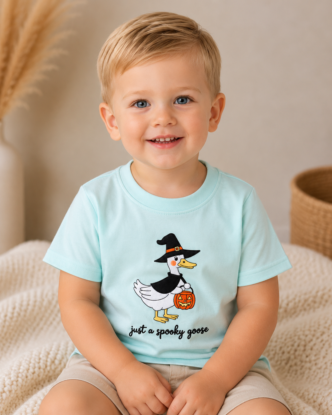 Toddler boy is wearing a Blue Spooky Goose Embroidered Top