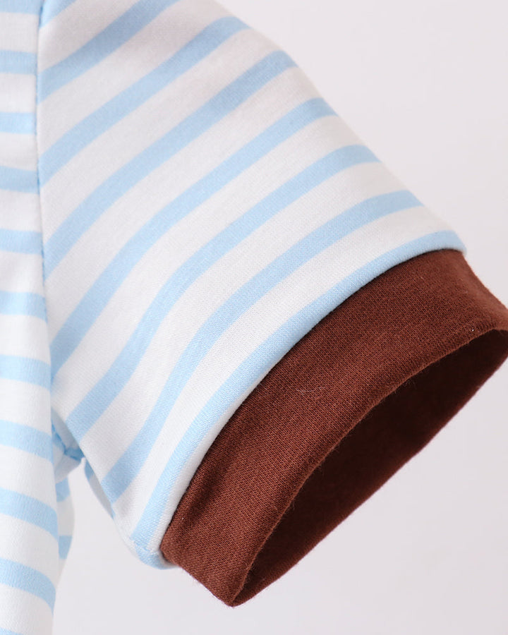 Close-up of a sleeve with blue and white stripes and a brown cuff on a light gray background