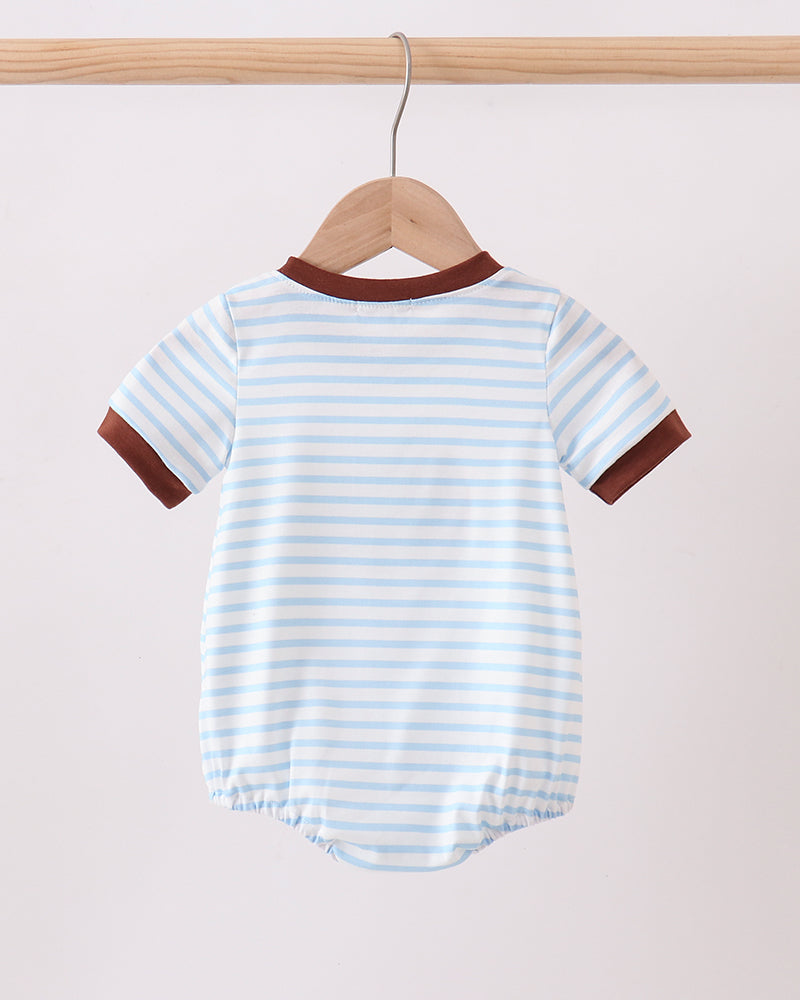 Baby onesie with blue and white stripes and brown accents on a wooden hanger against a beige background