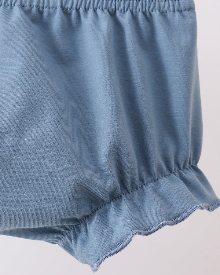 Close-up of blue baby bloomers on a light gray background