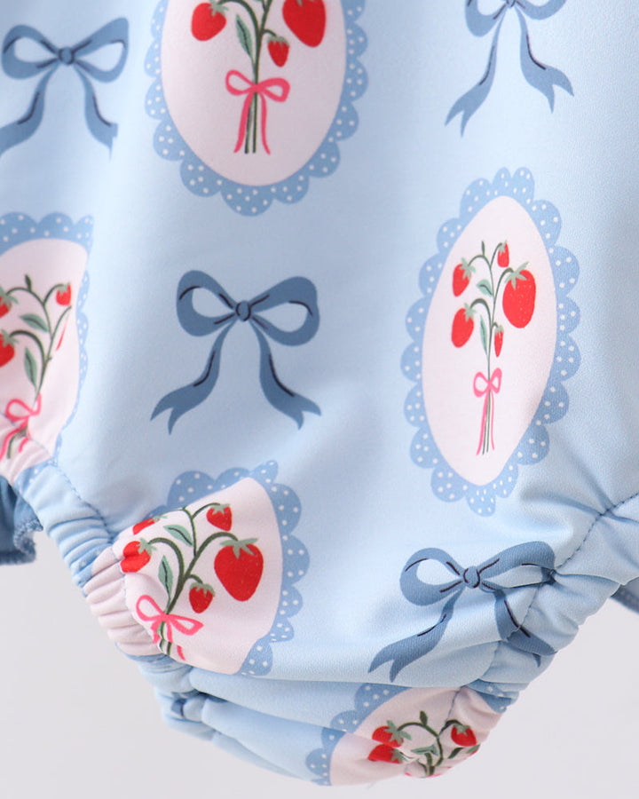 Swimsuit with strawberry and bow pattern on a light blue background