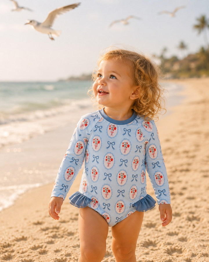 Toddler girl on a beach looking at birds