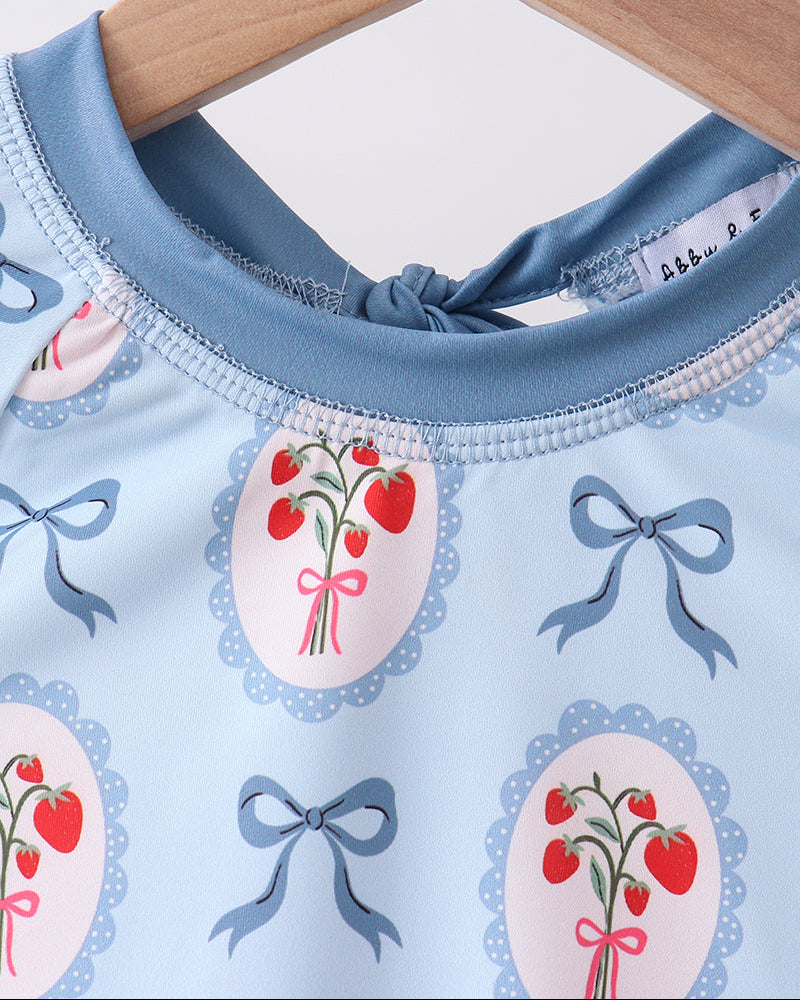 Rashguard with cherry and bow pattern on a hanger