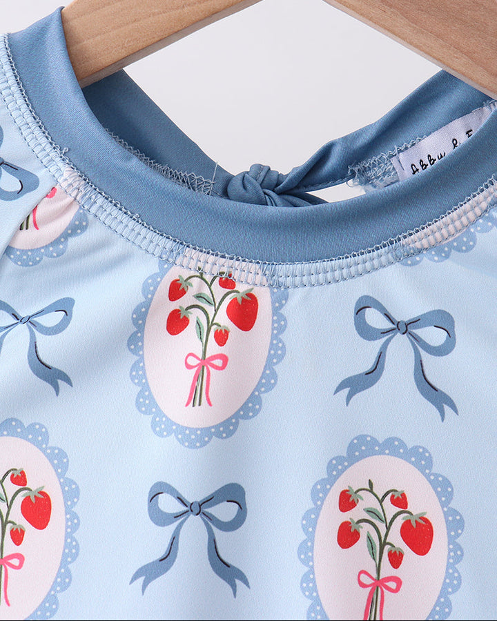 Rashguard with cherry and bow pattern on a hanger