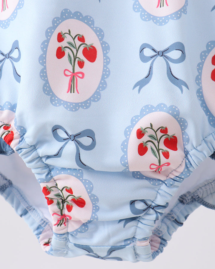 Rashguard with cherry and bow design on a light blue background