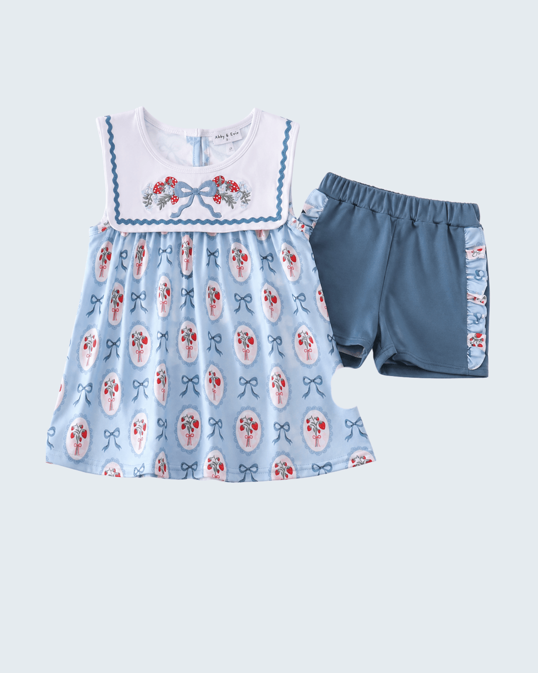 Children's outfit with a blue dress and shorts on a light gray background