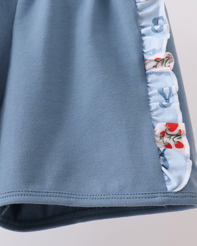 Blue shorts with floral trim on a light gray background