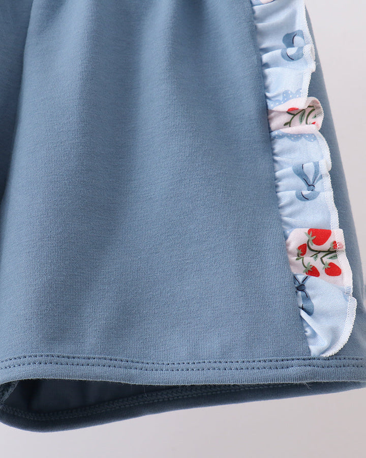 Blue shorts with floral trim on a light gray background