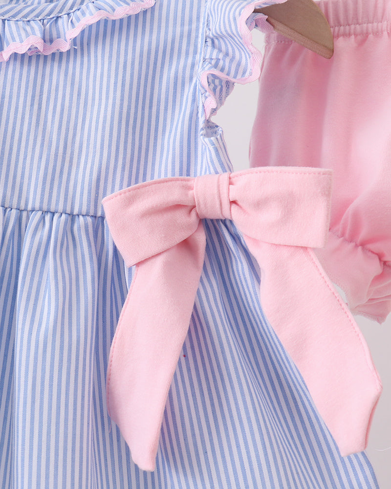 Close-up of a blue and white striped dress with a pink bow and matching shorts.