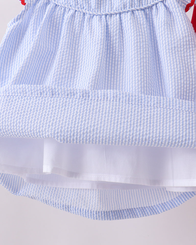 Close-up of a blue checkered dress with a white underlayer on a light gray background