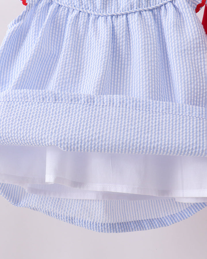 Close-up of a blue checkered dress with a white underlayer on a light gray background