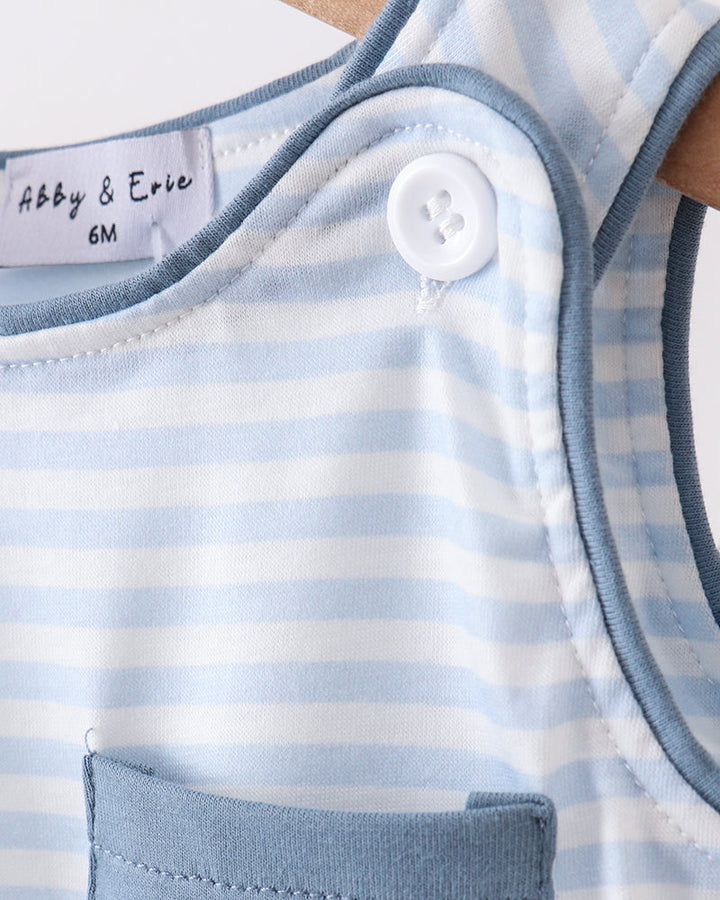 Close-up of a baby romper with blue and white stripes, a button, and a pocket.
