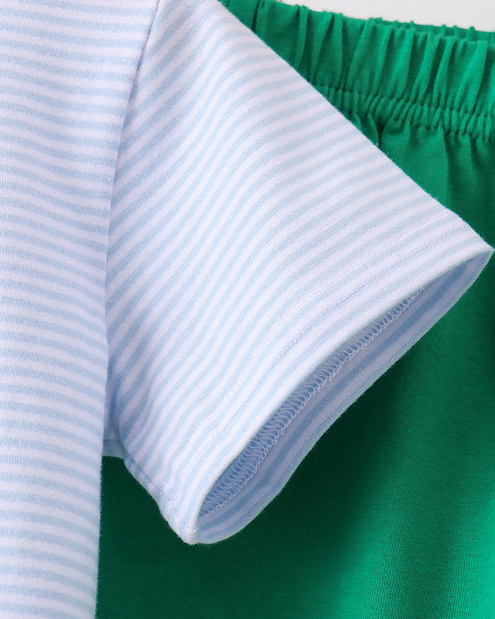 Light blue striped shirt sleeve and green shorts waistband with gathered elastic