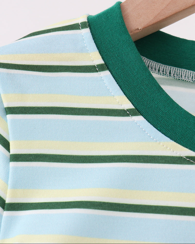 Close-up of a striped long-sleeve top on a wooden hanger, featuring a light blue base with horizontal green and pale yellow stripes, and a solid dark green ribbed collar.