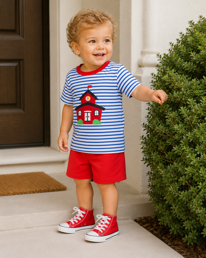 Child wearing striped T-shirt and red shorts set with schoolhouse applique