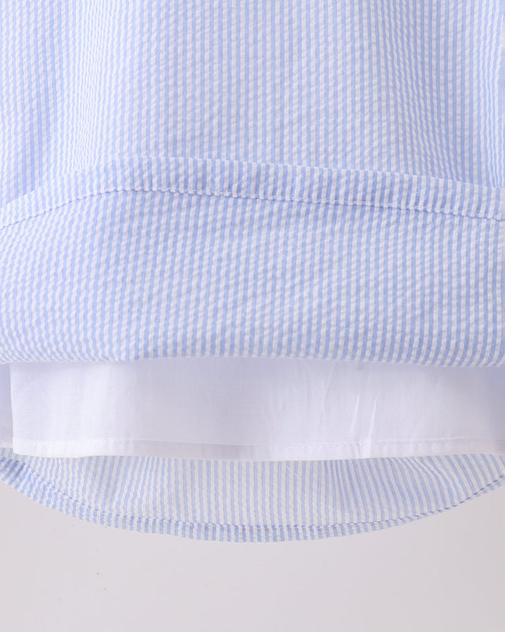 Close-up of a light blue and white checkered fabric with a white stripe.