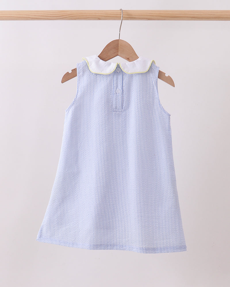 Blue striped dress with white collar on a wooden hanger against a light background