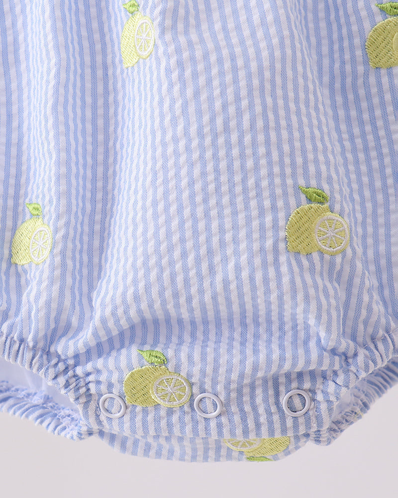 Blue and white striped baby romper with lemon designs on a light gray background