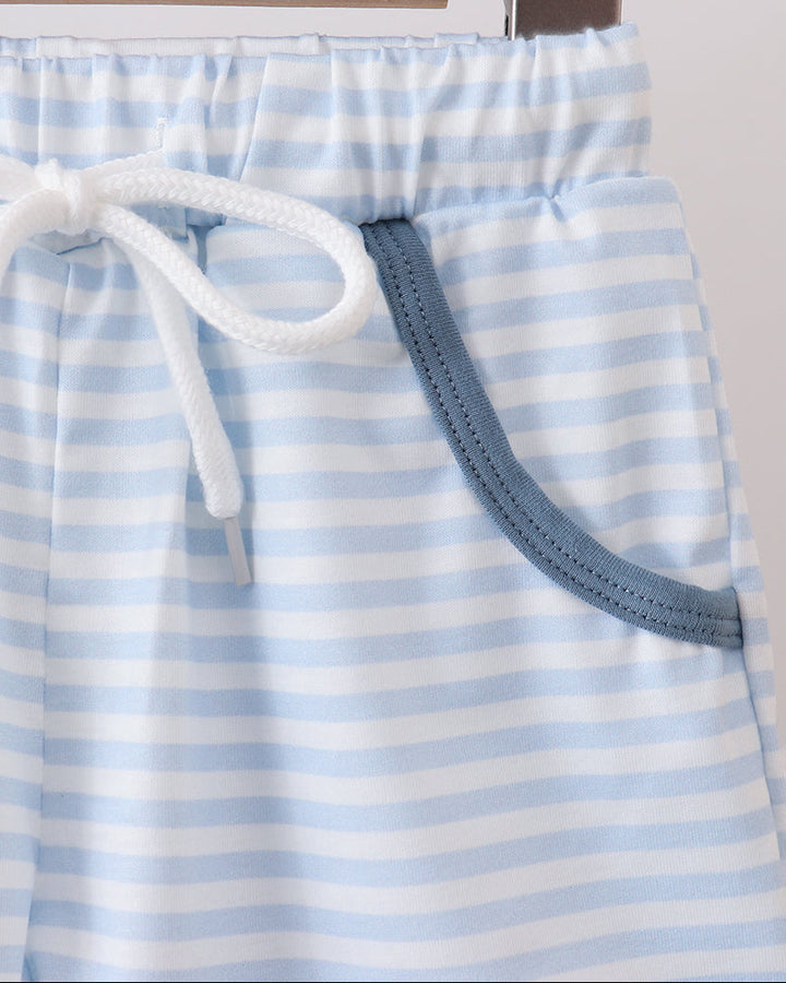 Blue and white striped shorts with drawstring on a hanger against a neutral background