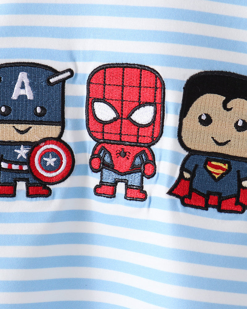 Close-up of a light blue and white striped fabric featuring three embroidered cartoon superhero patches: Captain America, Spider-Man, and Superman.
