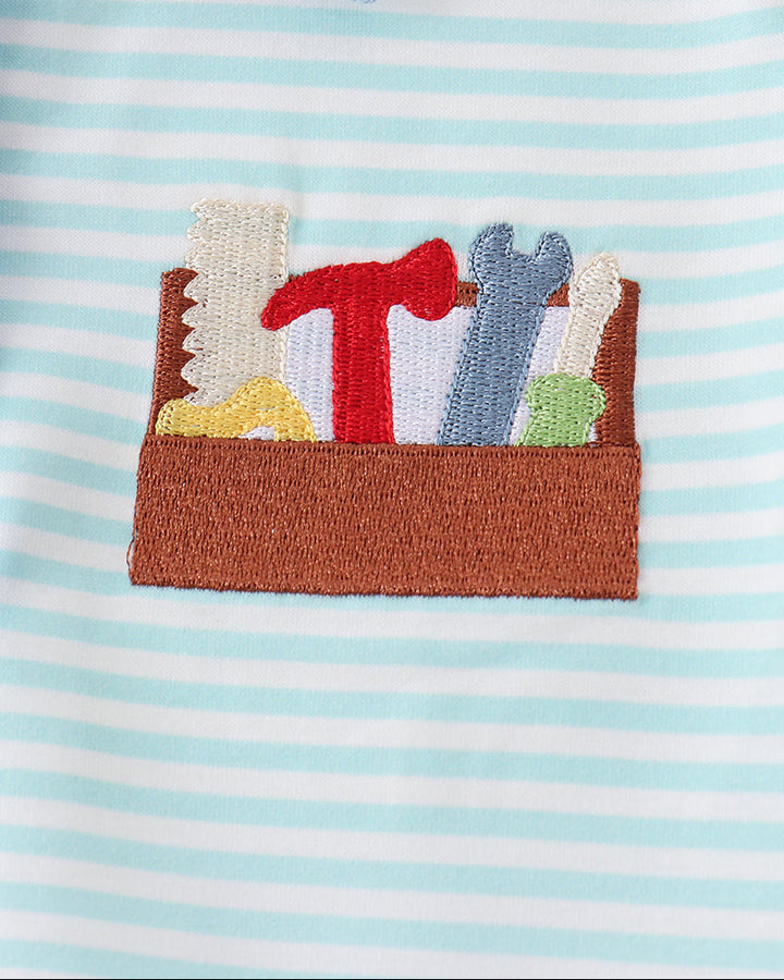 Light blue striped polo shirt with front pocket featuring colorful applique embroidery