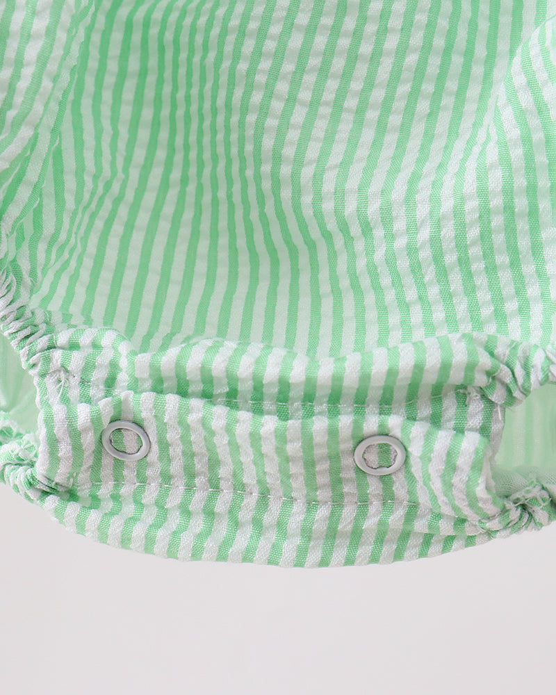 Green and white striped baby romper on a light gray background