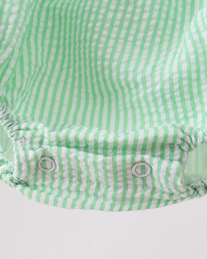 Green and white striped baby romper on a light gray background