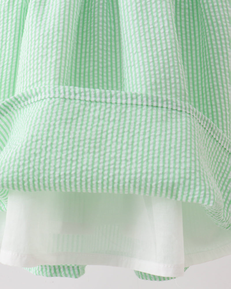 Close-up of a green and white checkered fabric with a pocket detail.