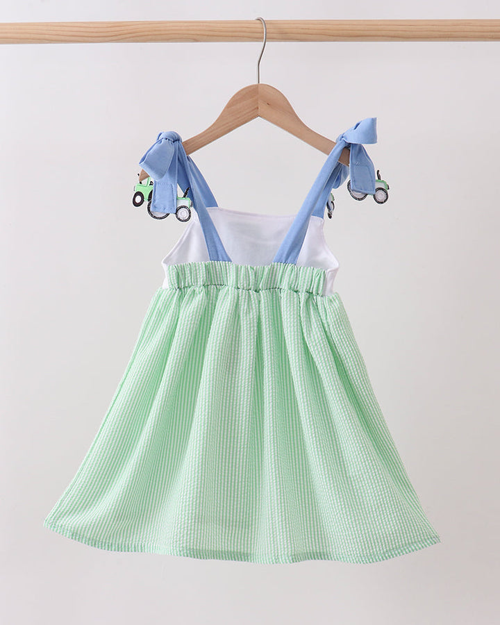 Green checkered dress with blue straps on a hanger against a white background