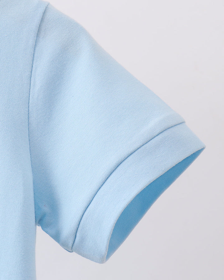Close-up of a light blue short-sleeve top showing the sleeve and ribbed cuff against a plain light background.