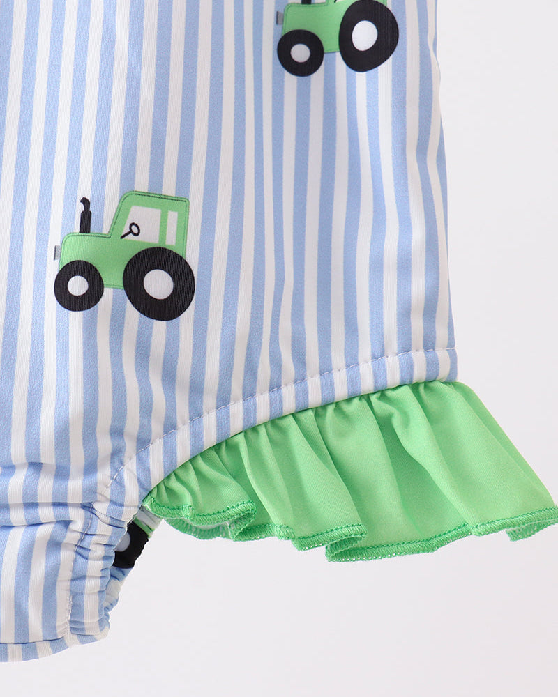 Striped swimsuit with green ruffle and tractor appliqués on a white background
