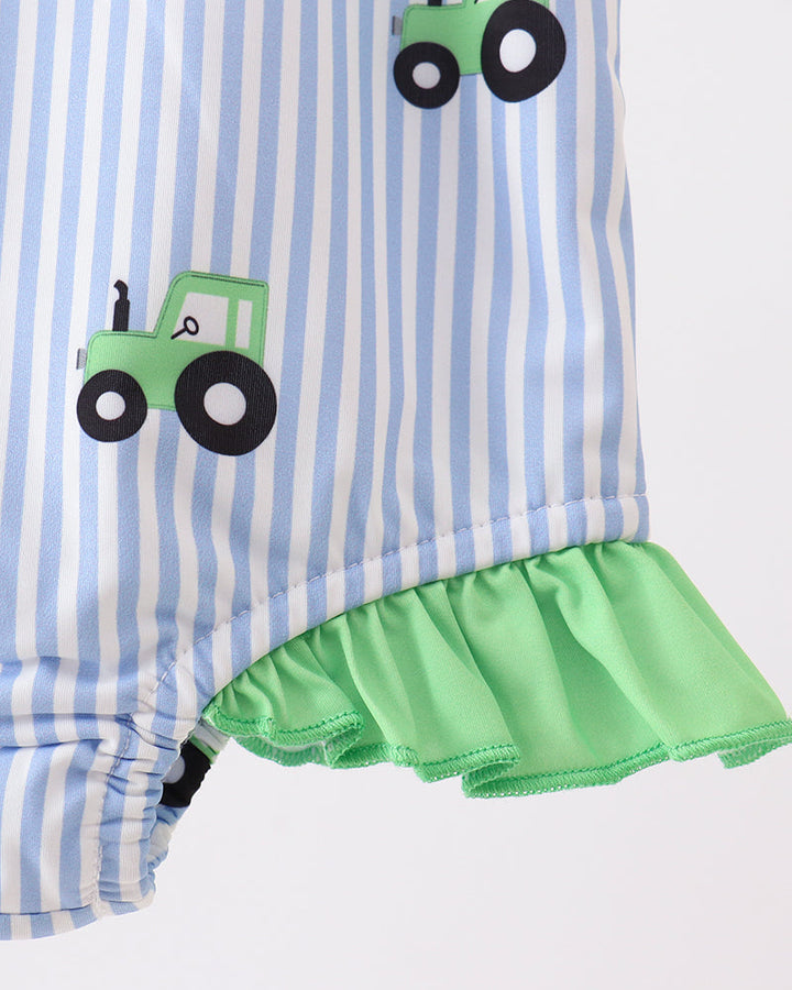 Striped swimsuit with green ruffle and tractor appliqués on a white background