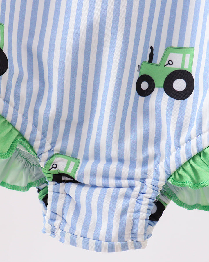 Striped baby romper with green tractor design on a white background