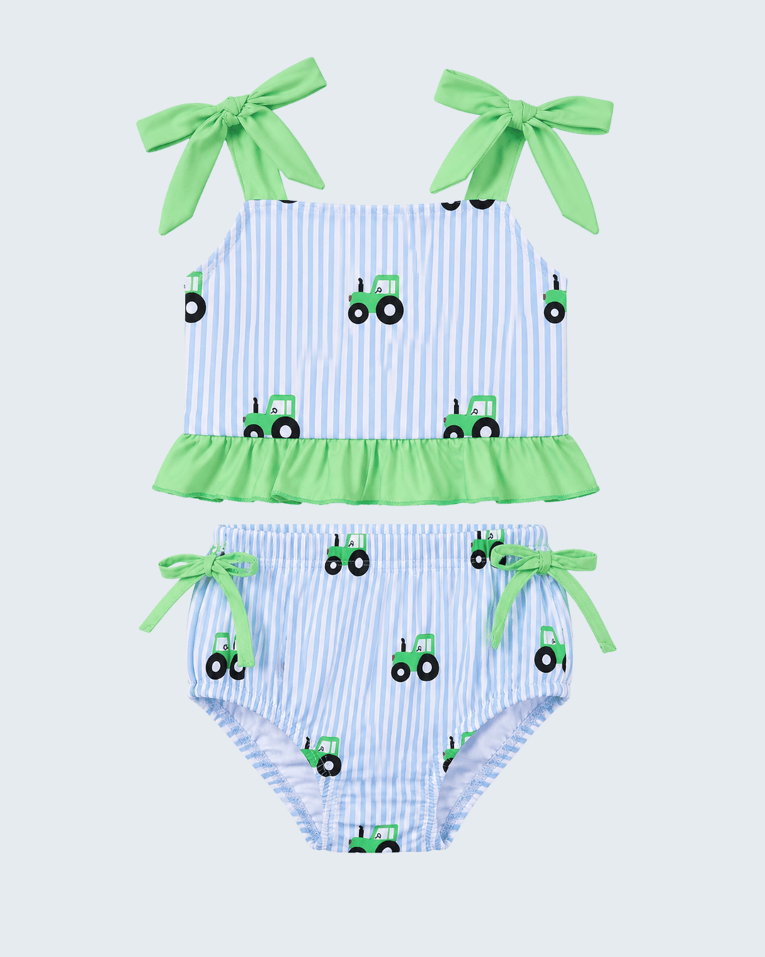 Two-piece swimsuit with green tractor pattern on a light blue background