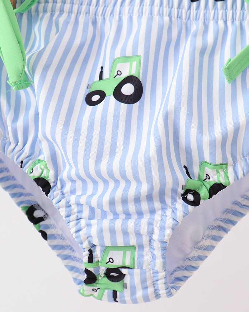 Baby swimsuit with blue and white striped pattern and green tractor design on a white background