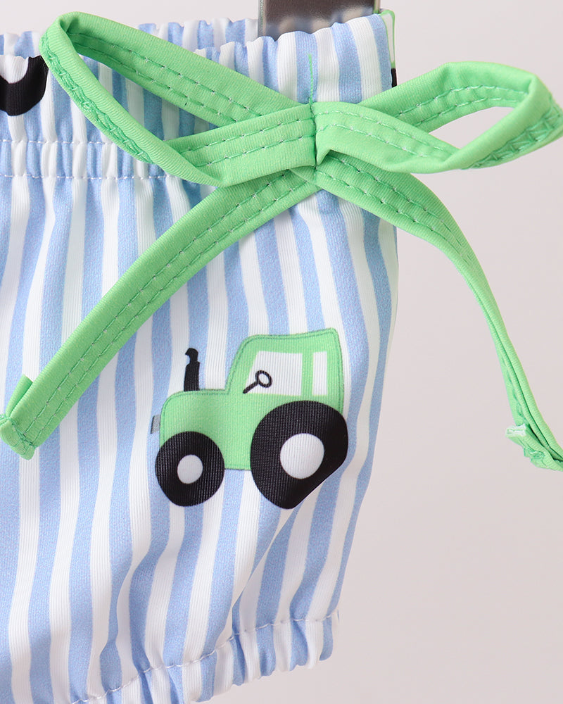 Striped swim bottoms with a green tractor design and green drawstring on a light gray background