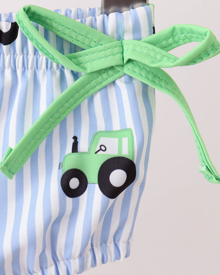 Striped swim bottoms with a green tractor design and green drawstring on a light gray background