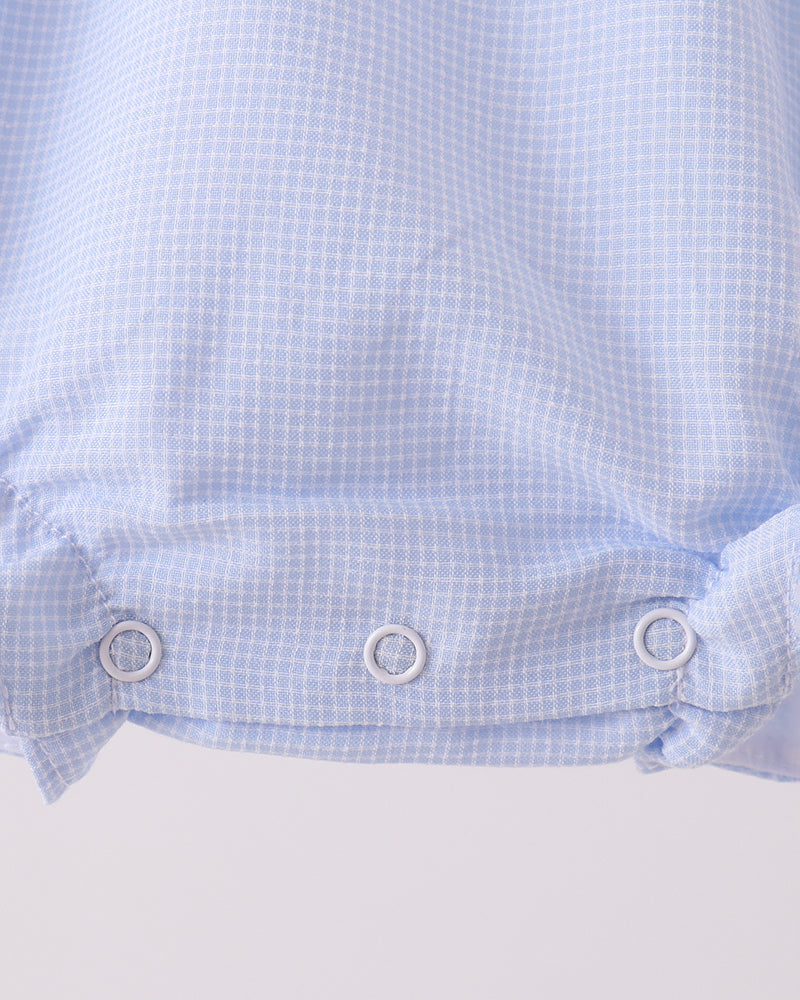 Light blue checkered romper with gathered waist and snap closure at bottom