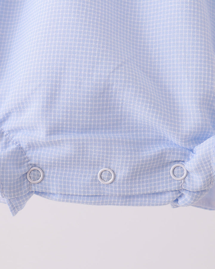 Light blue checkered romper with gathered waist and snap closure at bottom