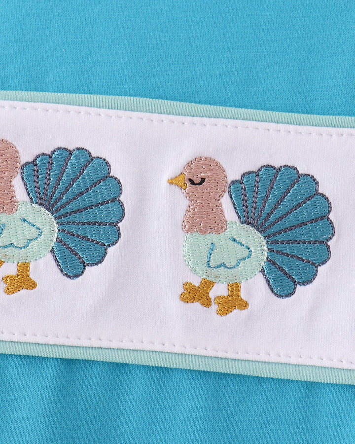 Turquoise top with white band and embroidered turkey and feather design