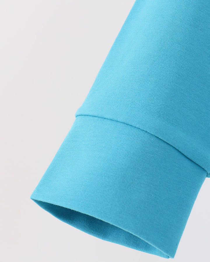 Turquoise long-sleeve top sleeve cuff close-up