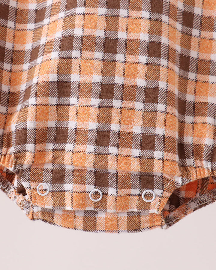 Orange-and-brown plaid baby bubble romper close-up with snap buttons at waist
